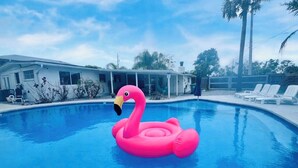 En pool med en rosa uppblåsbar flamingofigur att flyta på.
