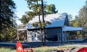 Un bâtiment à deux étages, doté d’un toit en métal, d’un porche couvert et d’un escalier menant à l’étage supérieur.