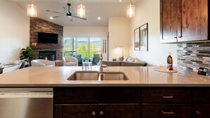 A modern kitchen with a large island, built-in appliances, and a stone accent wall. - Park City Summer Retreat | Near Hiking, Biking & Jordanelle (Kamas)