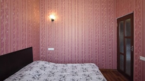 A bedroom with a bed, a wall-mounted light, and a door. - 21 Apartment in yerevan 02 (Yerevan)