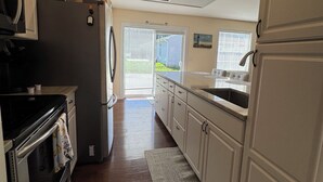 A modern kitchen with a refrigerator, stove, and microwave. - “It's A Shore Thing” located in beautiful Easton, MD. Close to MD & DE beaches. (Easton)