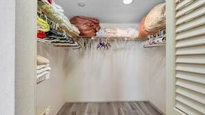 A walk-in closet with hanging storage, a folded blanket, and a radiator. - Lighthouse Towers - 1808 (Clearwater)