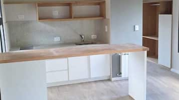 Cocina privada | Frigorífico pequeño, microondas, placa de cocina y utensilios de cocina