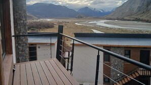 Un balcon avec vue sur une rivière et des montagnes.