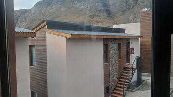Un bâtiment moderne doté d’un escalier, d’un extincteur et offrant une vue sur un paysage montagneux.