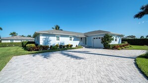 A two-story house with a paved driveway, a garage, and a well-maintained lawn. - Cozy retreat with Modern Comforts (Marco Island)