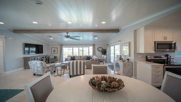 A spacious living area with a dining table, sofas, and a kitchen with modern appliances. - Cozy retreat with Modern Comforts (Marco Island)