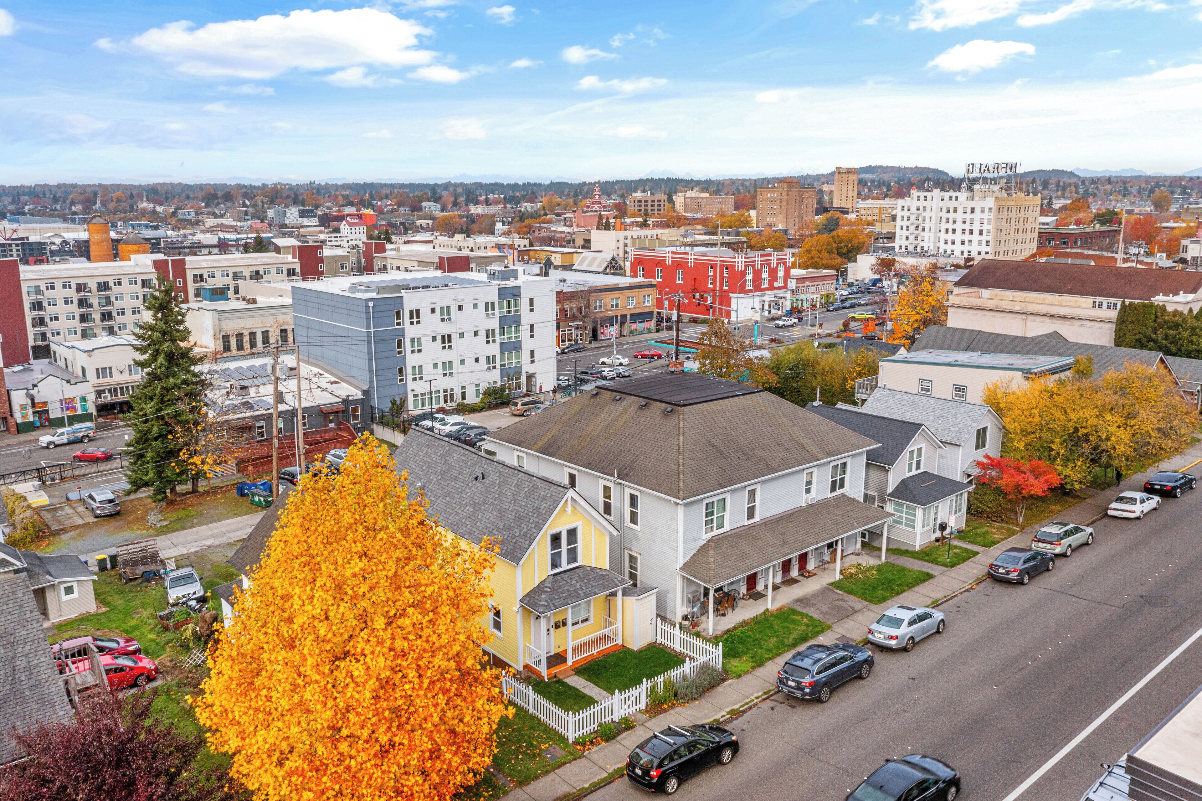 Ett bostadsområde med hus, en gata och en avlägsen stadsbild i bakgrunden.