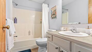 Une salle de bain équipée d’une baignoire, de toilettes, d’un lavabo et d’un meuble-lavabo.