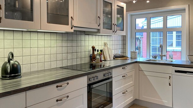 A modern kitchen with white cabinets, a built-in oven, and a window with multiple panes. - Awesome home in Skagen with WiFi (Skagen)