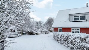 A snow-covered residential area with a red house, a pathway, and snow-laden trees. - Awesome home in Skagen with WiFi (Skagen)