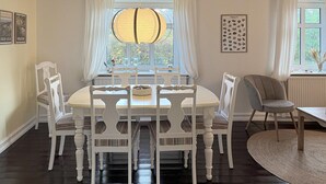 A dining area with a round table, white chairs, a hanging lamp, and a framed geological specimen on the wall. - Awesome home in Skagen with WiFi (Skagen)