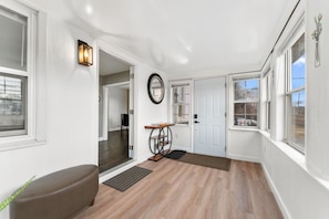 A hallway with a bench, a door, a mirror, and a light fixture. - Large 3BR Home Near Dulles w/parking sleeps 8 (Centreville)