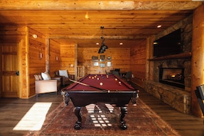 A pool table in a wooden room with a fireplace and seating area. - Whippoorwill Estate - Spa | Mini Golf | B Ball (Mineral Bluff)
