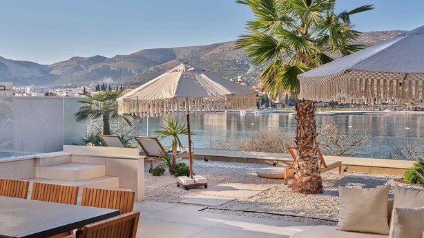 A rooftop terrace with a pool, lounge chairs, and a dining area overlooking a mountainous landscape. - Luxury Villa Lunea with Pool VII (Trogir)