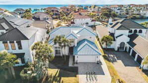 Il s'agit d'un quartier résidentiel situé sur la côte, où les maisons présentent un mélange de styles architecturaux, notamment une maison remarquable avec un toit bleu et une allée où sont garés des vélos.