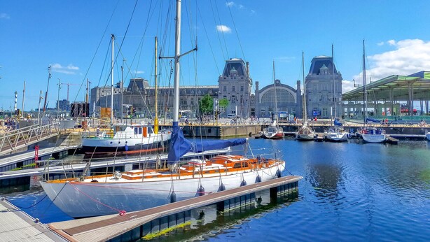A marina with boats docked, a bridge, and a historic building in the background. - Cozy apartment in Oostende (Oostende)