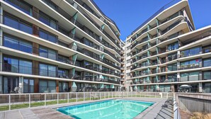 A modern multi-story residential building with a central swimming pool surrounded by balconies. - Cozy apartment in Oostende (Oostende)