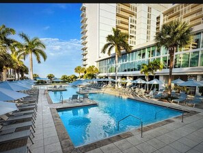 A hotel pool area with multiple swimming pools, sun loungers, and umbrellas. - Marriott Crystal Shores Two Bedroom Gulf View Villa (Marco Island)