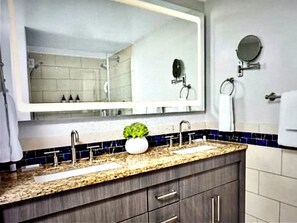 A bathroom with a double sink vanity, a large mirror, and a small potted plant. - Marriott Crystal Shores Two Bedroom Gulf View Villa (Marco Island)