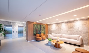 A modern lobby with a reception desk, seating area, and an elevator. - Your Complete Stay in Salvador, Just Minutes From the Beach and Shopping Barra - Hgrs (Salvador)