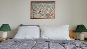 A bed with white pillows, a grey patterned blanket, and two green lamps on either side. - Strathcona Views - Blueberry (Comox-Strathcona C)