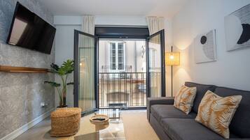 Departamento Deluxe, vista a la ciudad | Área de sala de estar | Televisión