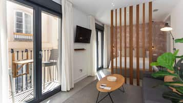 Monolocale Deluxe, balcone, vista città | Area soggiorno | TV