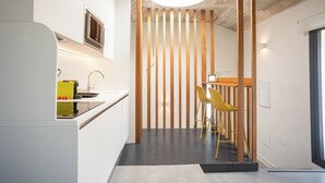 Een moderne keuken met een inbouwmagnetron, een gele broodrooster en een houten wand.