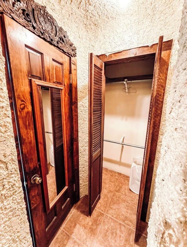Une salle de bain avec une porte en bois, un espace douche et un porte-serviettes.