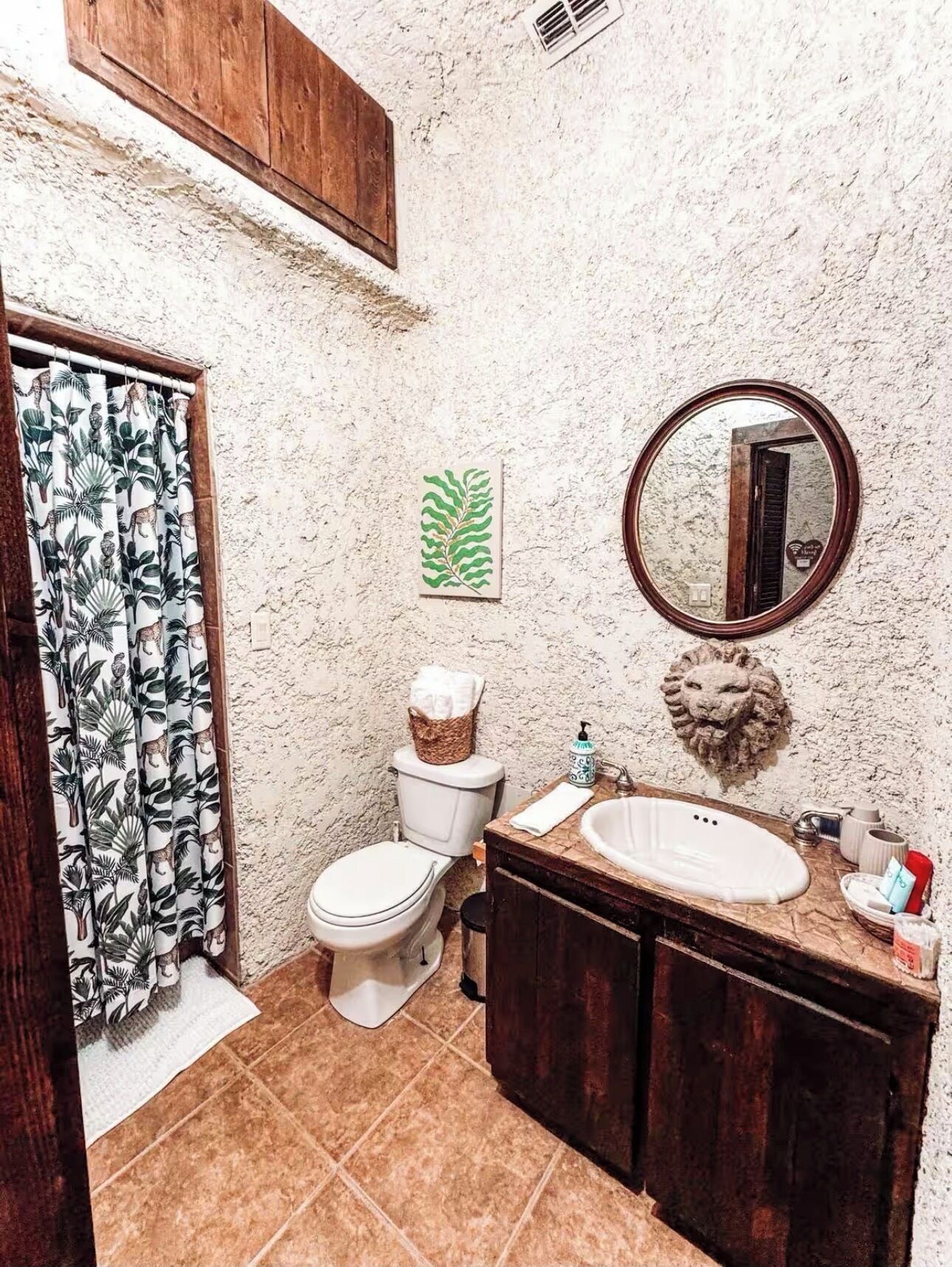 Une salle de bain avec des toilettes, un lavabo et un miroir.