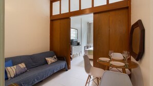 A living room with a sofa, dining table, chairs, and a TV. - Comfort in Copacabana - STC405 (Rio de Janeiro)