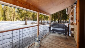 A wooden deck with a metal railing, a bench, and a welcome sign. - Brand New Cozy Glacier Cabin (Coram)