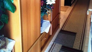 Un armario de madera con espejo, una planta pequeña y un adorno en la puerta.