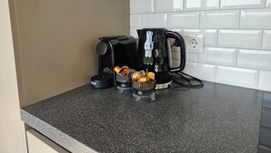 A kitchen counter with a coffee maker, a kettle, and a container of tea bags. - Hítarneskot – Private Hot Tub Cottage in Snæfellsnes (Borgarnes)