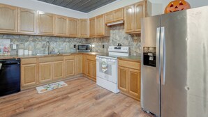A kitchen with wooden cabinets, a stainless steel refrigerator, a microwave, and a stove. - Cozy Couple’s Escape w/ Patio in Northwest Georgia (Calhoun)