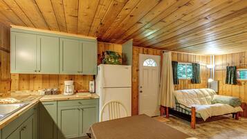 L’intérieur d’une cabane comprend une cuisine, un coin repas et une chambre à coucher.