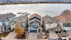 A residential area with houses, a dock, and a lake with mountains in the background. - Lakefront Home w/ Mountain Views • Walk to Shops (Sparks)