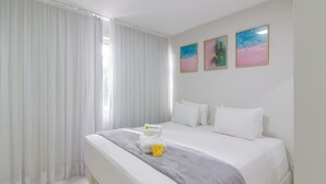 A hotel room with a large bed, white curtains, and three framed pictures on the wall. - Acogedor Rinc n en Ipanema Ac2002 (Rio de Janeiro)