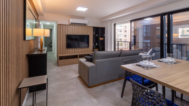 A modern living room with a sofa, TV, and dining table with chairs. - Maravilla en Leblon Jq406 (Rio de Janeiro)