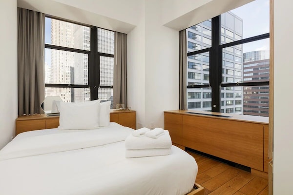 Wake up to skyline light in crisp, cloud-soft bedding.