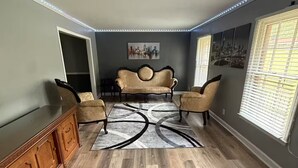 Un salón amplio con un sofá grande, dos sillones y un aparador de madera.