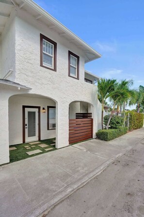 A two-story house with a white exterior, a front door, and a garage door.