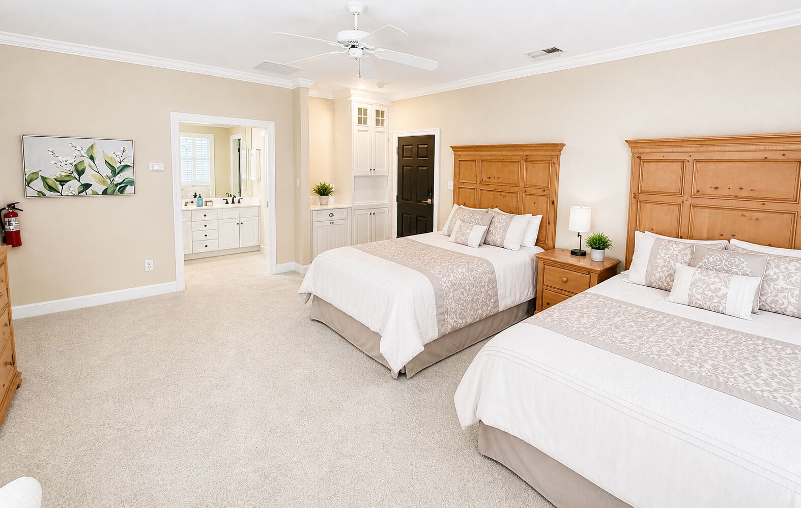 A bedroom with two beds, a ceiling fan, a nightstand, and a dresser.