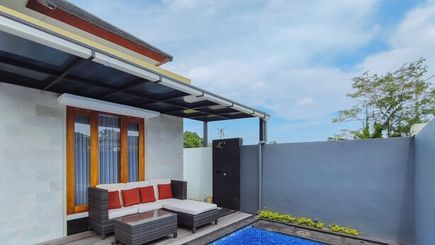 Un espace piscine extérieur moderne, doté d’un coin salon intégré et d’un patio couvert.