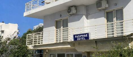 A multi-story hotel with balconies and air conditioning units.