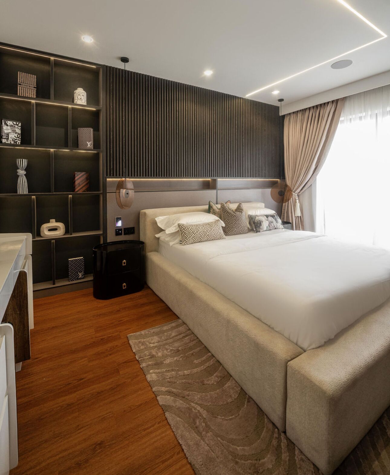 Un dormitorio moderno con una cama grande, un armario empotrado y una mesita de noche.