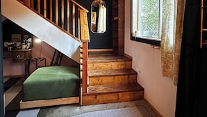 Eine Treppe mit Holzhäuschen und einem grünen Kissen am Fuß.