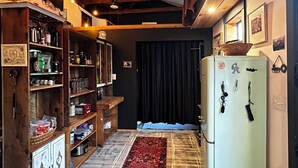 Eine rustikale Küche mit Holzbalken, einem Kühlschrank und einem gemusterten Teppich.