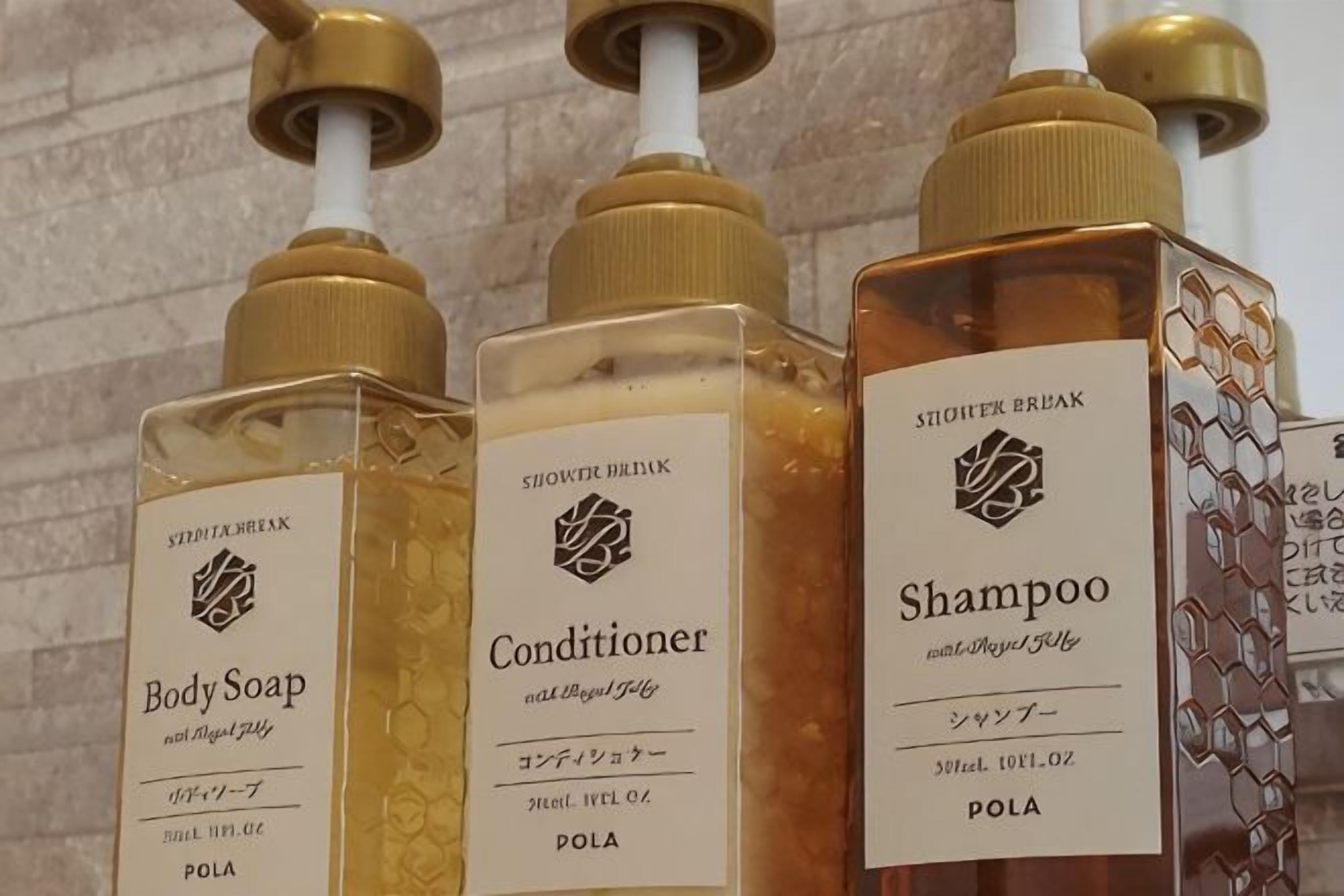 Three bottles of shower break products: body soap, conditioner, and shampoo.
